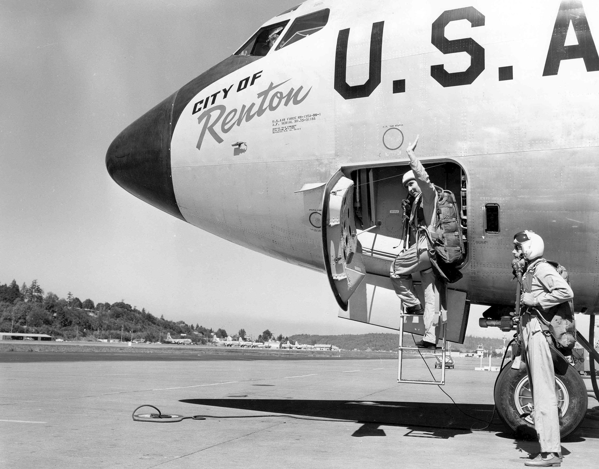 black and white photo of pilots climbing into the nose of the KC-135