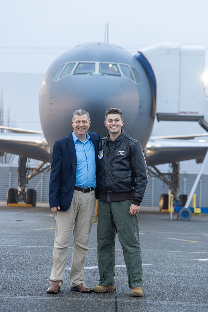Boeing employee Eric Thorley and his son, 1st Lt Zachary Thorley, pose arm in arm on the flight line, in front of the KC-46A Pegasus delivered to Lt Thorley’s squadron.