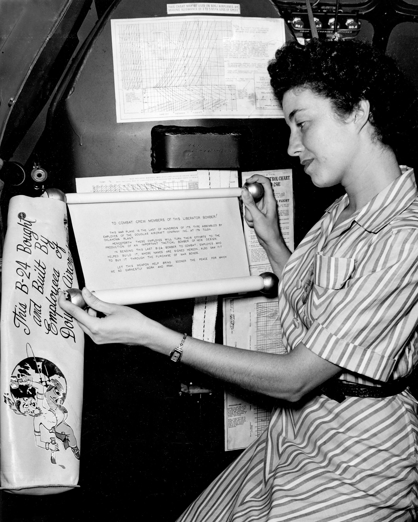 A black and white photo of a woman holding up a sign.