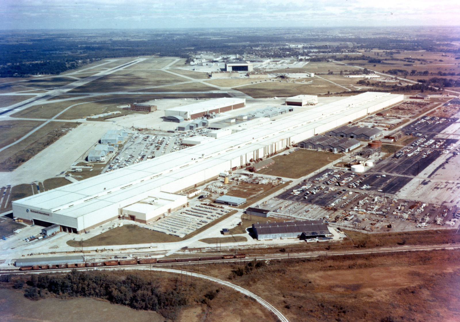 A color aerial image of a white building - the Rockwell facility - in the 1990s.