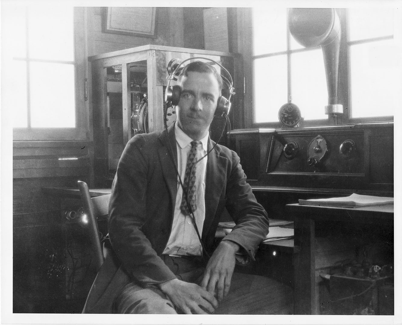 lack and white photo of man wearing headset.