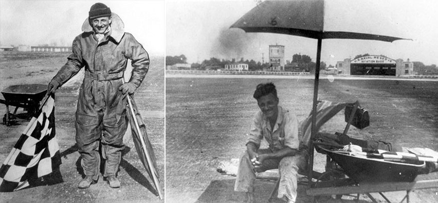Black and white photo of man in jump suit holding flags.