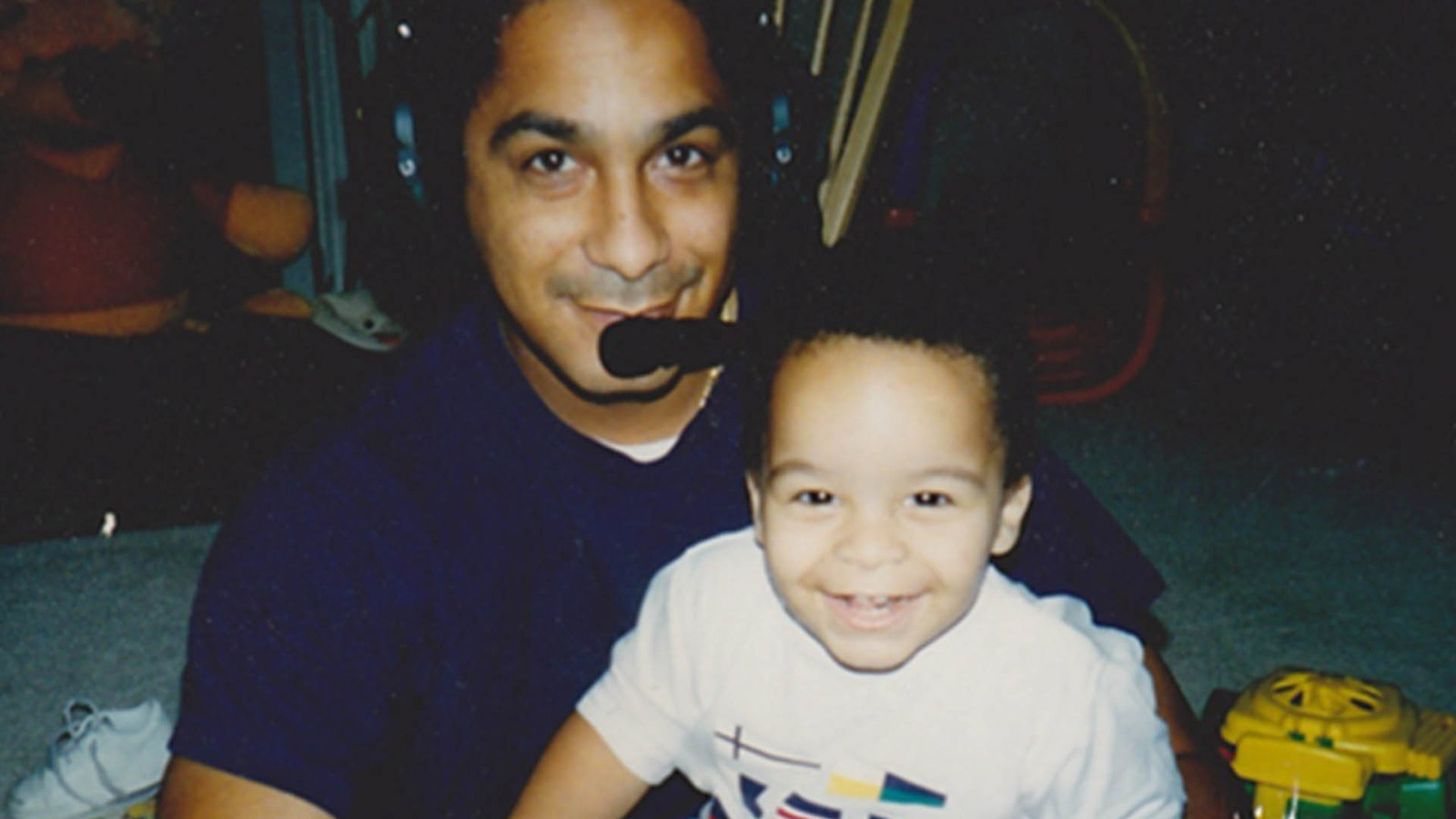 Employee as a toddler with his father, a pilot, pretending to fly an aircraft