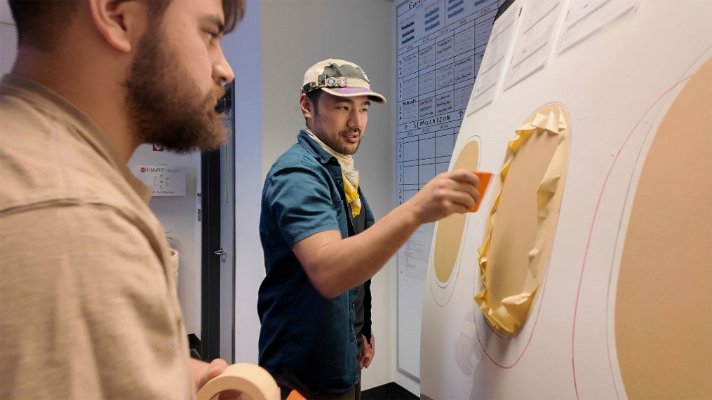 Instructor demonstrating how to mask an aircraft panel during a hands‑on lesson