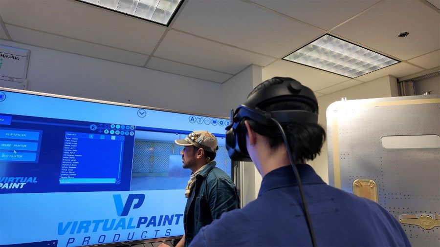 Instructor and trainee reviewing painting options on a large VR training screen
