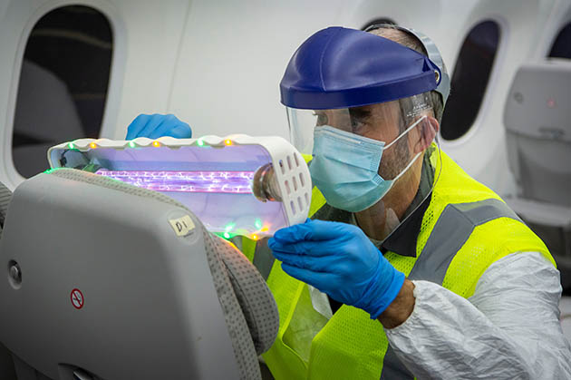 Boeing engineer Kevin Callahan with UV wand in airplane cabin