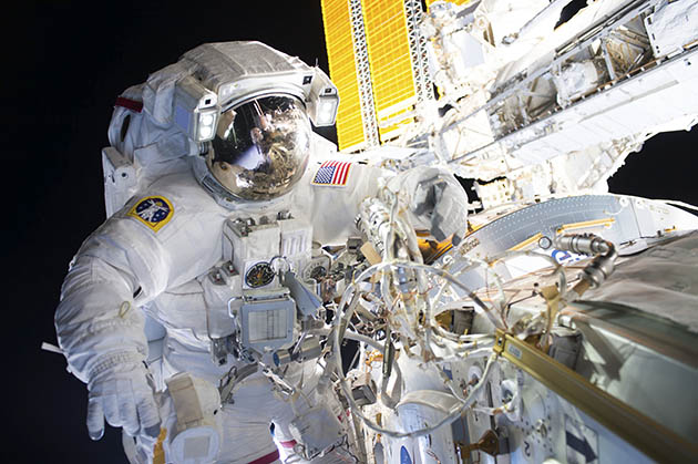 NASA astronaut wires the Boeing-made International Docking Adapter in place on the International Space Station