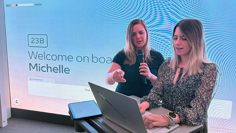 woman speaks into microphone and second woman uses keyboard
