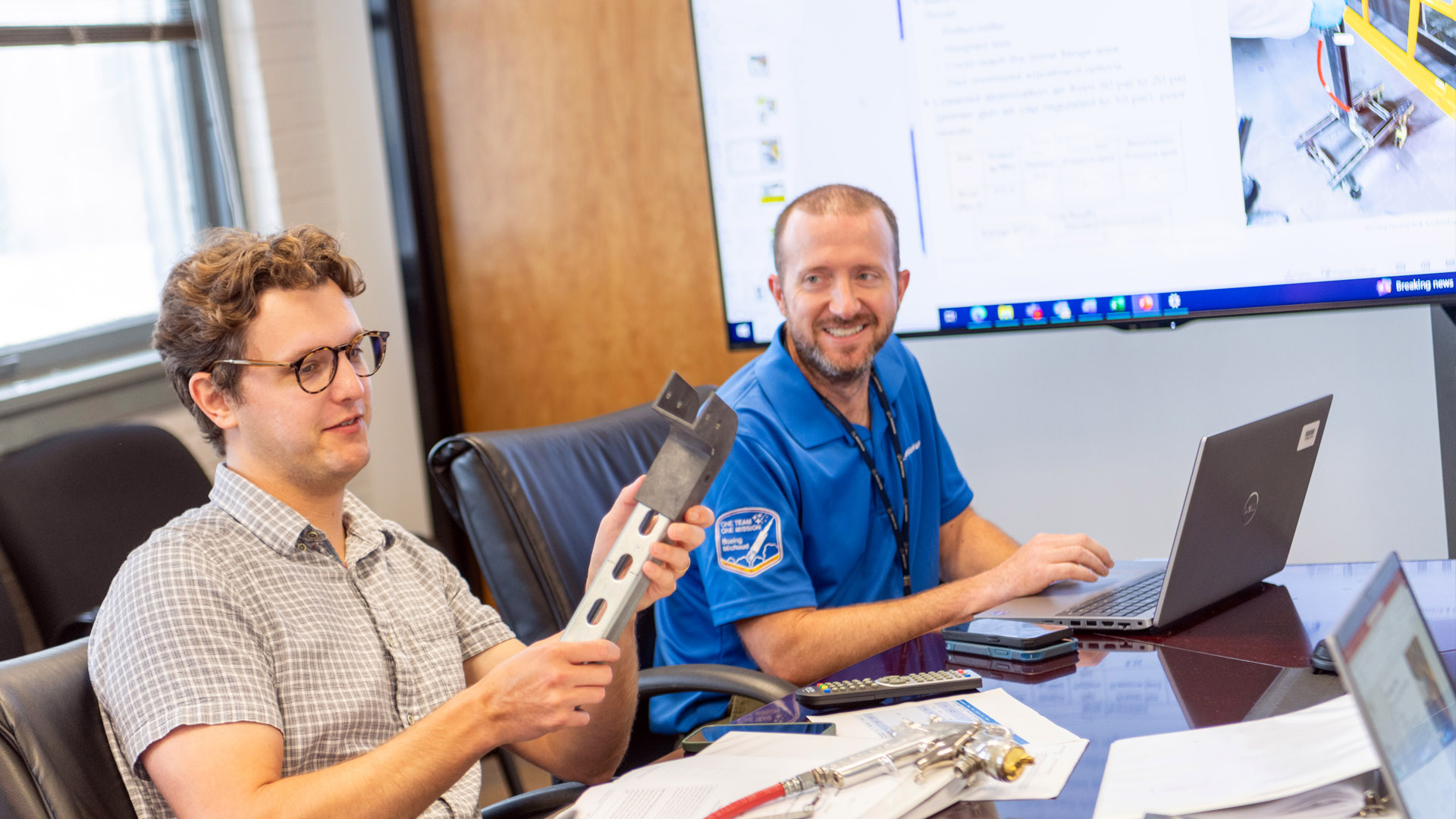 one person holds piece of spray device and one person enters information at laptop