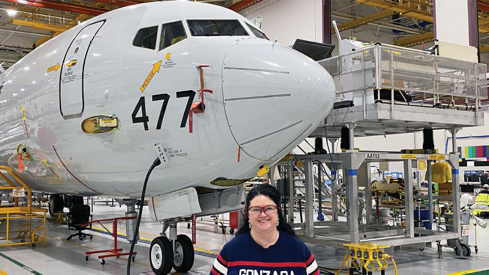 Deputy chief engineer stands in front of P-8 Poseidon aircraft
