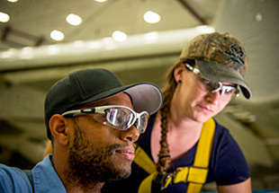  Picture of man and woman in bump caps wearing safety glasses. Supply Chain Management 