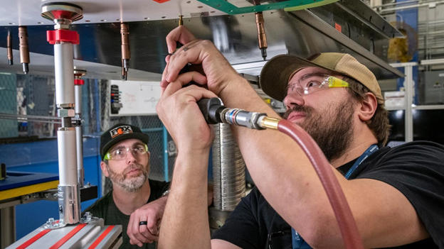 Boeing employees in factory using training mock-up