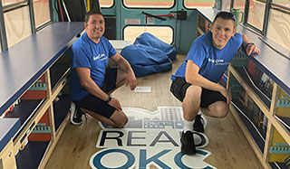 Chris Silvano (right) and Oklahoma City teammates pack books onto buses with Boeing partner ReadOKC. The Book Buses visit Oklahoma City Public Schools, allowing students to select a book of their choice to add to their home library.