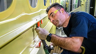 Mohammadamin Zekavati rivets brackets on a 777X lower wing skin panel