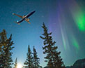 Image of the 7 3 7 dash 8 with Aurora Borealis in the background.