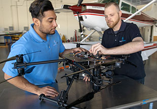 Picture of staff working with UAS vehicle.