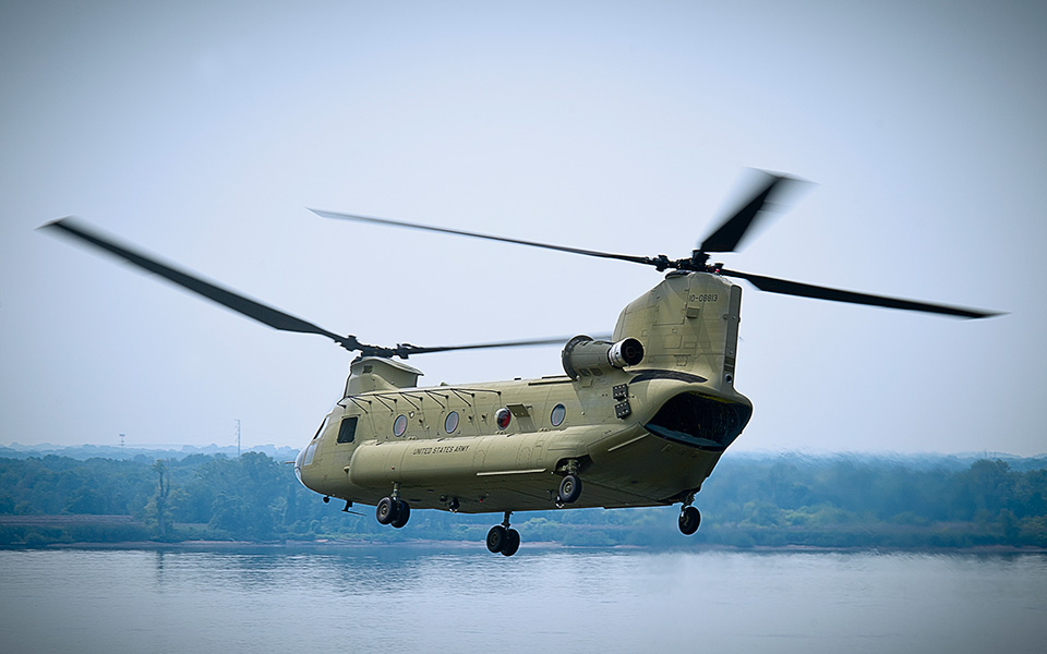 Picture of a CH-47 F Chinook hover over water.