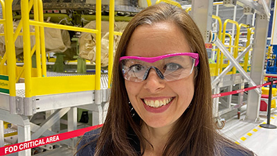 Liz Poul pauses for a photo in front of the Starliner after it returned from space in December 2019 following the Orbital Flight Test. (Boeing photo)