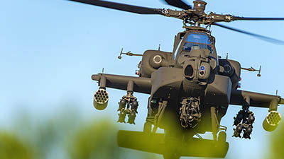 Boeing Apache Helicopter flying with plants in the foreground