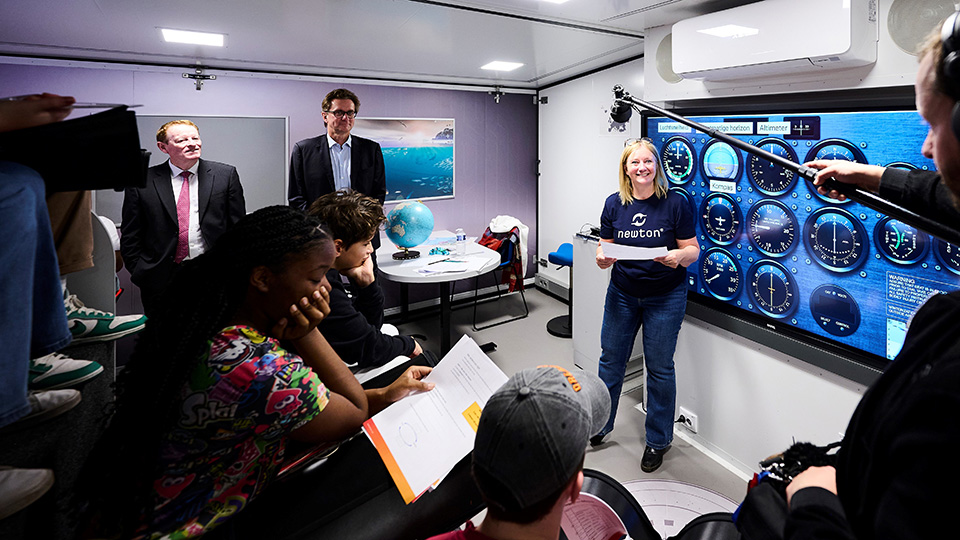 Belgian students using an aircraft simulator inside the Mobile Newton Room.