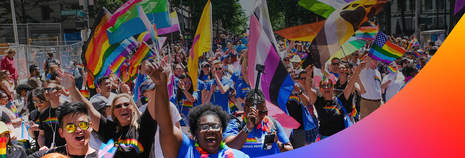 Boeing employees and friends wave flags and cheer at a Pride parade