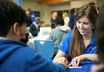 Two people sitting at a table at a community engagement event.