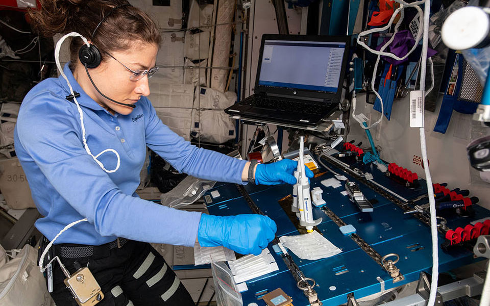 Picture of female astronaut at a work station.
