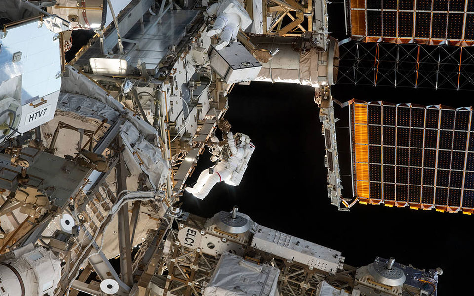 Picture of an astronaut working outside space station.