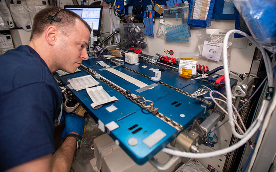 Picture of male astronaut at a workstation.