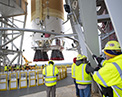 Picture of the Boeing Space Launch System with staff at launch pad.